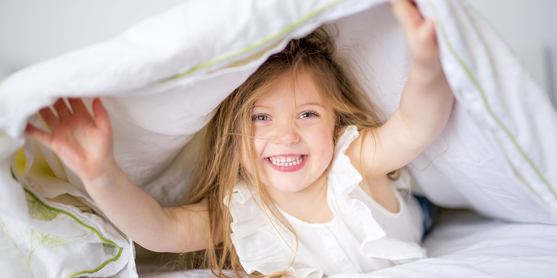 Ein Mädchen guckt unter der Bettdecke hervor., © Fotolia / pololia
