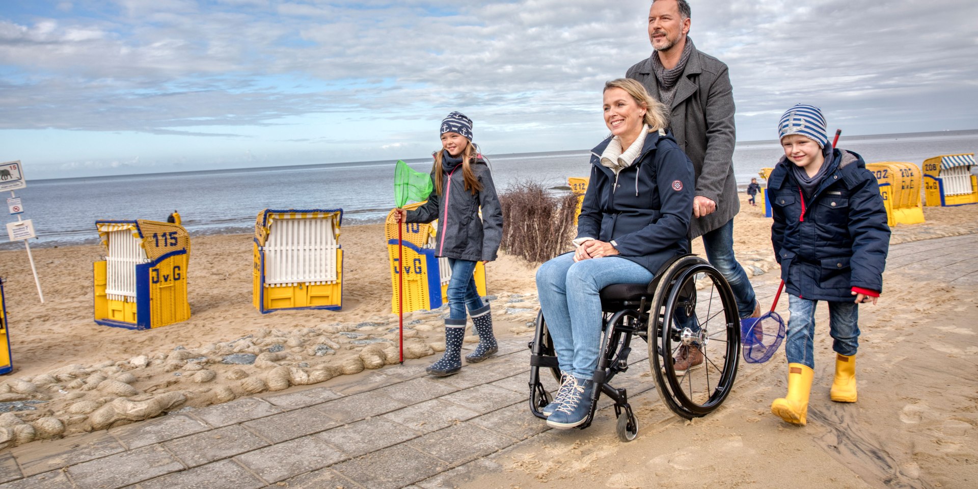 Familie am Nordsee Strand und die Mutter sitzt in einem Rollstuhl, © TourismusMarketing Niedersachsen GmbH / Christian Bierwagen
