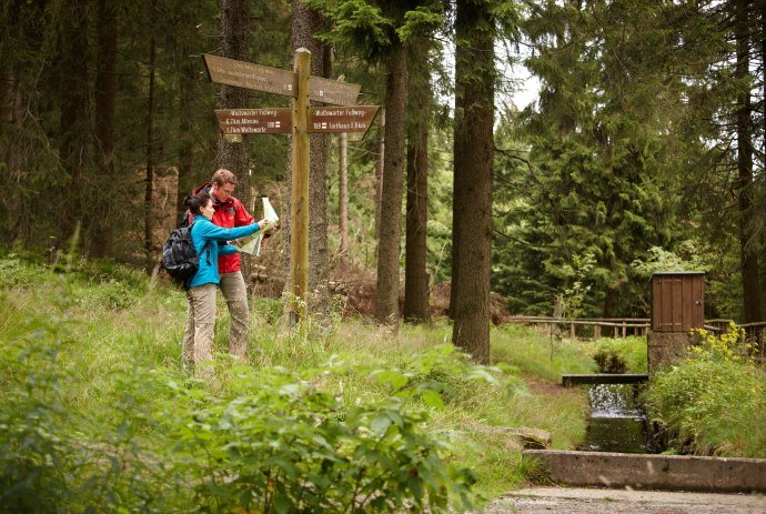 Wandererpaar liest Karte an Wegweiser, © Harzer Tourismusverband / M.  Gloger