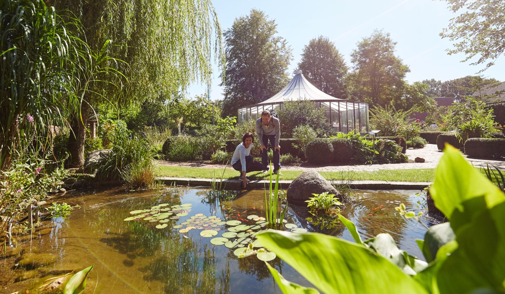 Zwei Menschen schauen sich einen Teich im Bibelgarten Werlte an, © Naturpark Hümmling