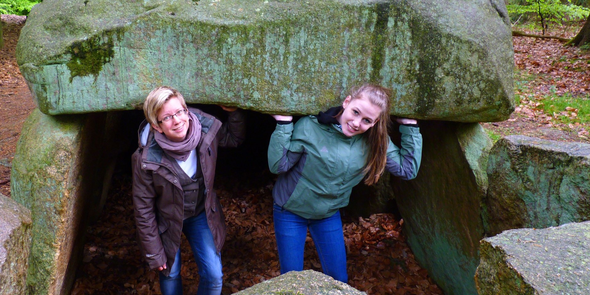 Die Grabkammer des Steinfelder Großsteingrabes wird entdeckt von zwei jungen Frauen., © Touristikverband Landkreis Rotenburg (Wümme)  e.V. / Udo Fischer