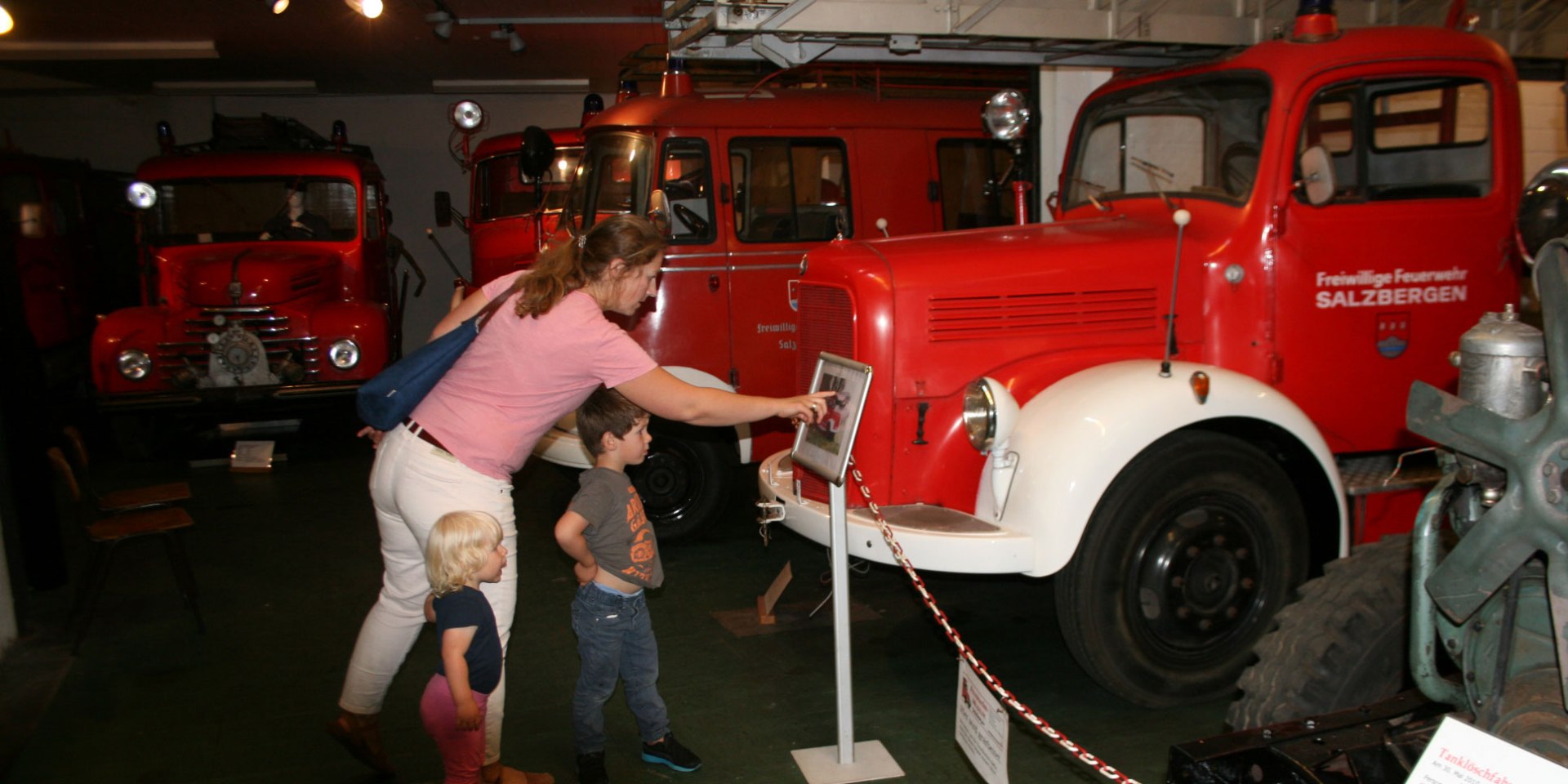 Mutter zeigt zwei Kindern ein Feuerwehrauto, © Feuerwehrmuseum Salzbergen / Marcus Droste