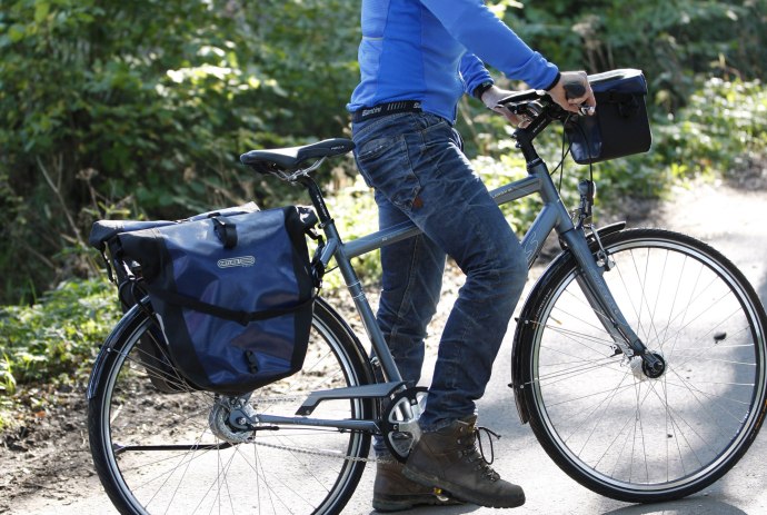Radfahrer mit zwei Packtaschen am Fahrrad, © TMN / Peter Hamel